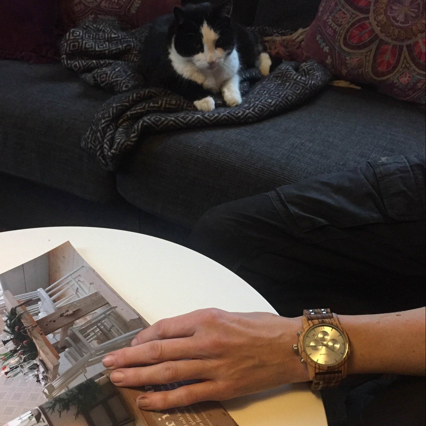 Katten ligger och tittar på en träklocka av zebraträ. Naturligt och unikt. Naturligt unikt. Concordia, signalerar ut vem du är. Perfekt bröllopspresent eller present till ert träbröllop, alla hjärtans dag, till din pokvän, flickvän, till födelsedagen, mors dag, fars dag eller kanske en julklapp