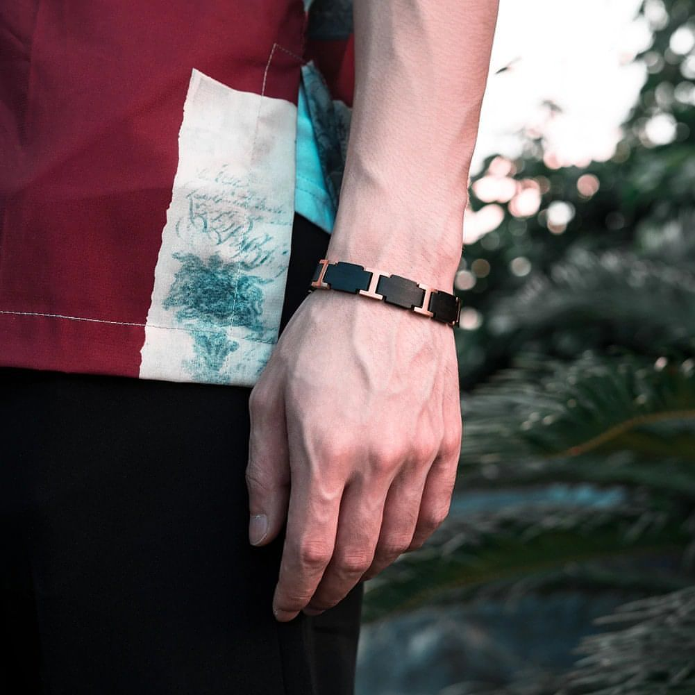 En man bär ett armband av trä på armen. Ett armband som signarerar ut vem du är