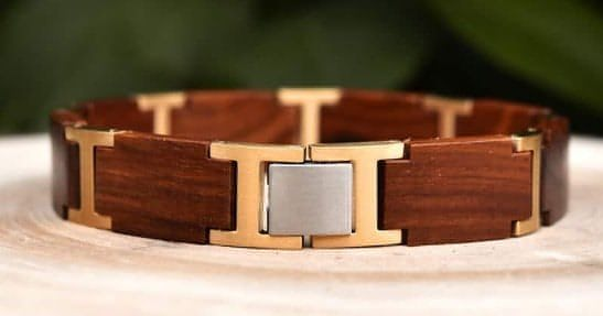 Ett unikt, ekologiskt, handgjort armband av naturmaterial och rostrfitt stål. Här i rött Sandelträ och "guld"eloxerat rostfritt stål